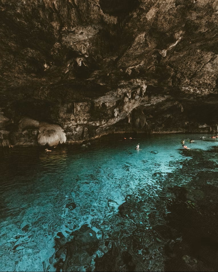 Interior view of Cenote Dos Ojos staircase access showing safety railings and water clarity for tourists