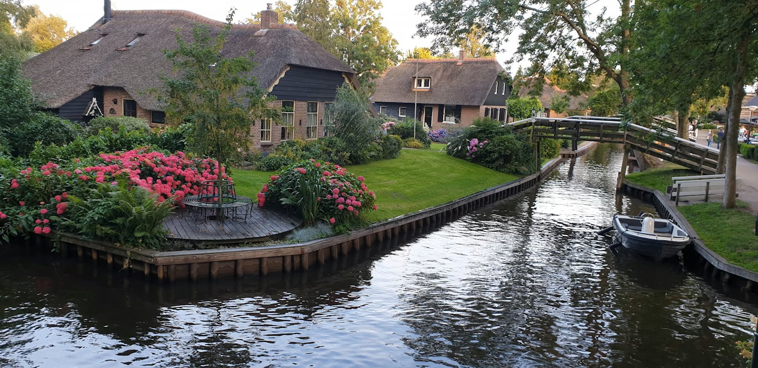 Traditional thatched-roof cottages in Giethoorn village Netherlands along the Amsterdam to Groningen road trip route.