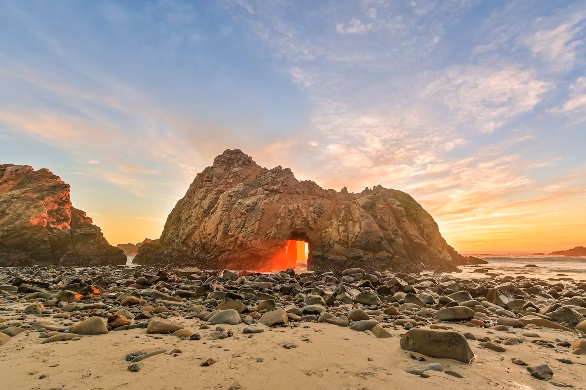 Keyhole Arch rock formation at Pfeiffer Beach with purple-tinted sand