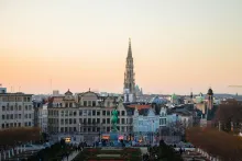 Panoramic view of Brussels with Grand Place architecture, ornate guild houses, historic rooftops, and the city skyline glowing under warm evening light in Belgium.