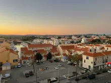 Panoramic view of Faro old town with whitewashed buildings, historic rooftops, palm trees, and the Algarve coastline in Portugal.