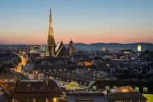 Panoramic view of Vienna, Austria featuring grand imperial architecture, ornate historic buildings, St. Stephen’s Cathedral, and elegant city streets along the Danube under soft golden light.