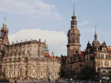 Panoramic view of Dresden, Germany, featuring the Elbe River, historic baroque skyline, domes and bridges, and surrounding green hills under a soft morning sky.