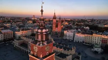 Panoramic view of Krakow, Poland, featuring the historic Old Town, St. Mary’s Basilica towers, Wawel Castle overlooking the Vistula River, colorful rooftops, and centuries-old architecture under a bright daytime sky.