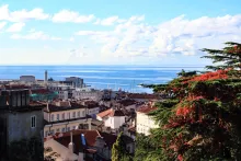 Panoramic view of Trieste, Italy, featuring Piazza Unità d'Italia, the Adriatic waterfront, elegant historic architecture, and Miramare Castle overlooking the Gulf of Trieste on a clear Mediterranean day.