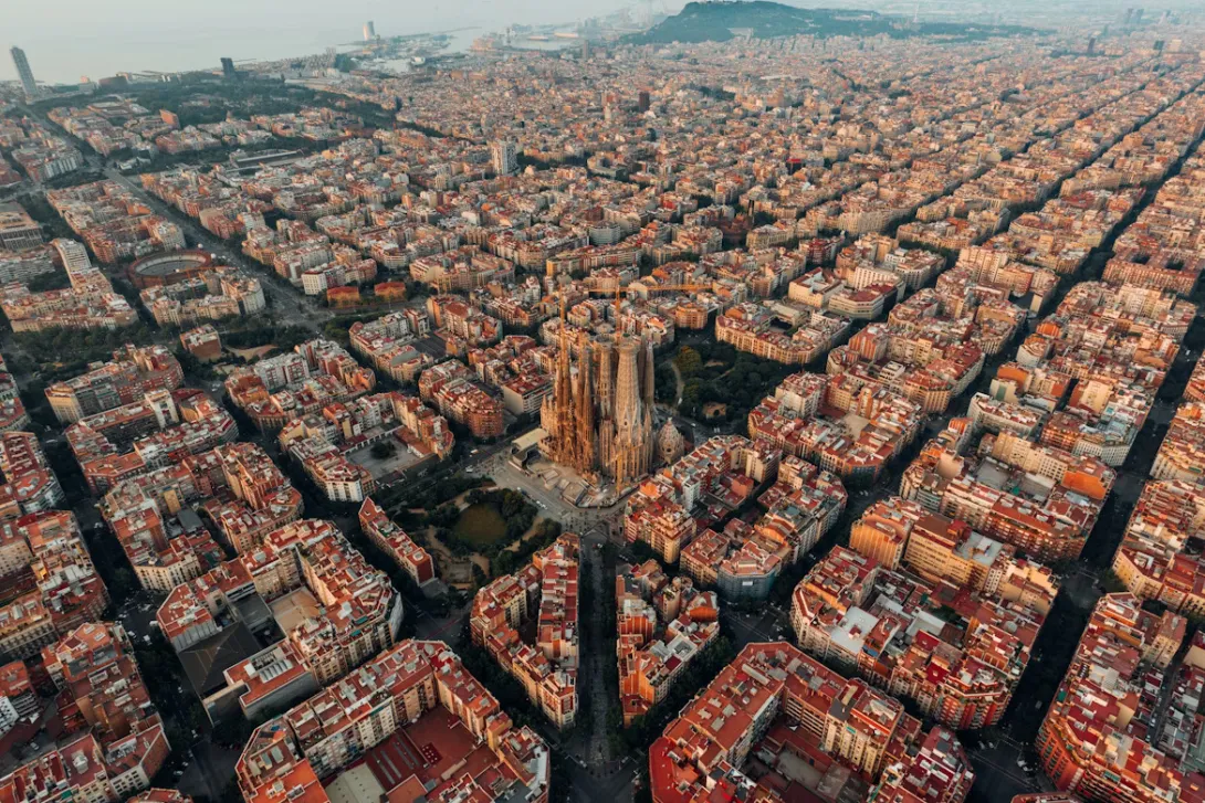 Aerial view of Barcelona streets with colorful city blocks, historic buildings, and Mediterranean urban architecture in Spain.