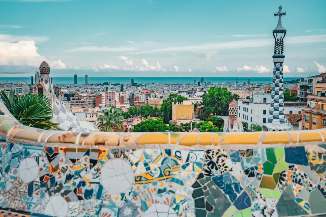 Panoramic view of Barcelona featuring the Sagrada Família, Mediterranean coastline, and colorful city architecture in Spain.
