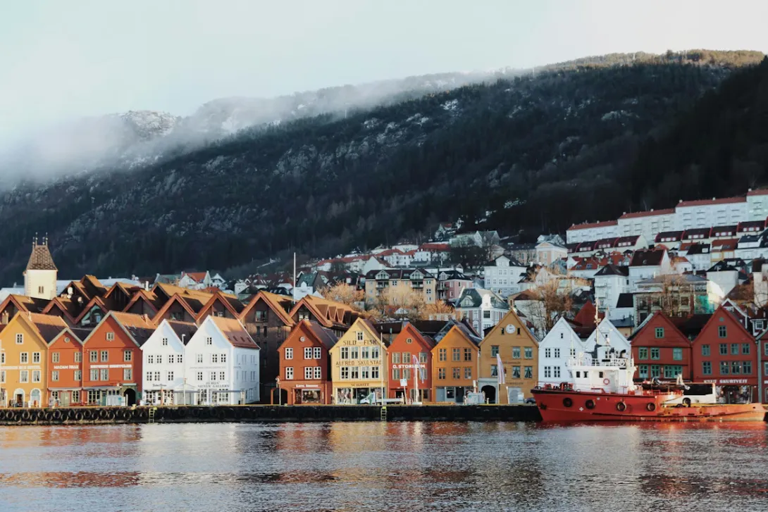 Scenic view of Bergen with colorful wooden houses along the harbor and surrounding fjords in Norway.