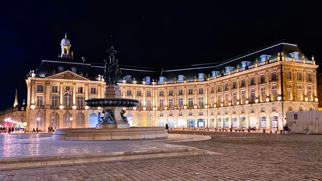 View of Bordeaux with elegant historic architecture, the Garonne River, and waterfront buildings in southwestern France.