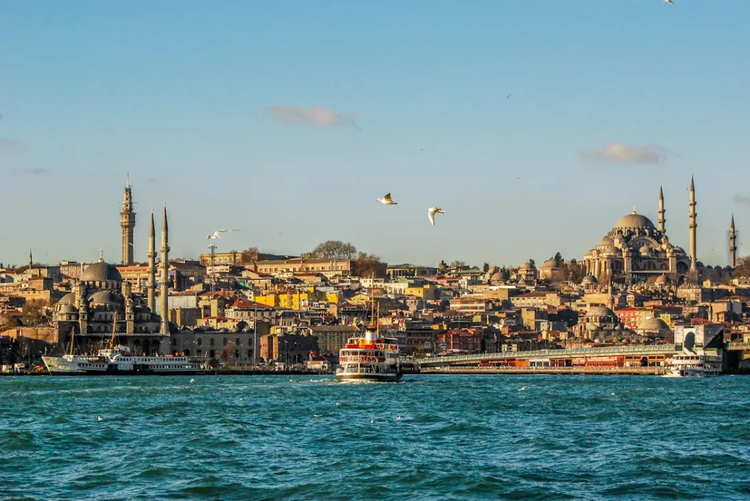 View of Istanbul with the Bosphorus, historic mosques, and the city skyline at sunset in Turkey.
