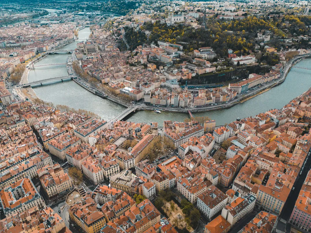 Panoramic view of Lyon with historic buildings, the Saône River, and Basilica of Notre-Dame de Fourvière overlooking the city in France.