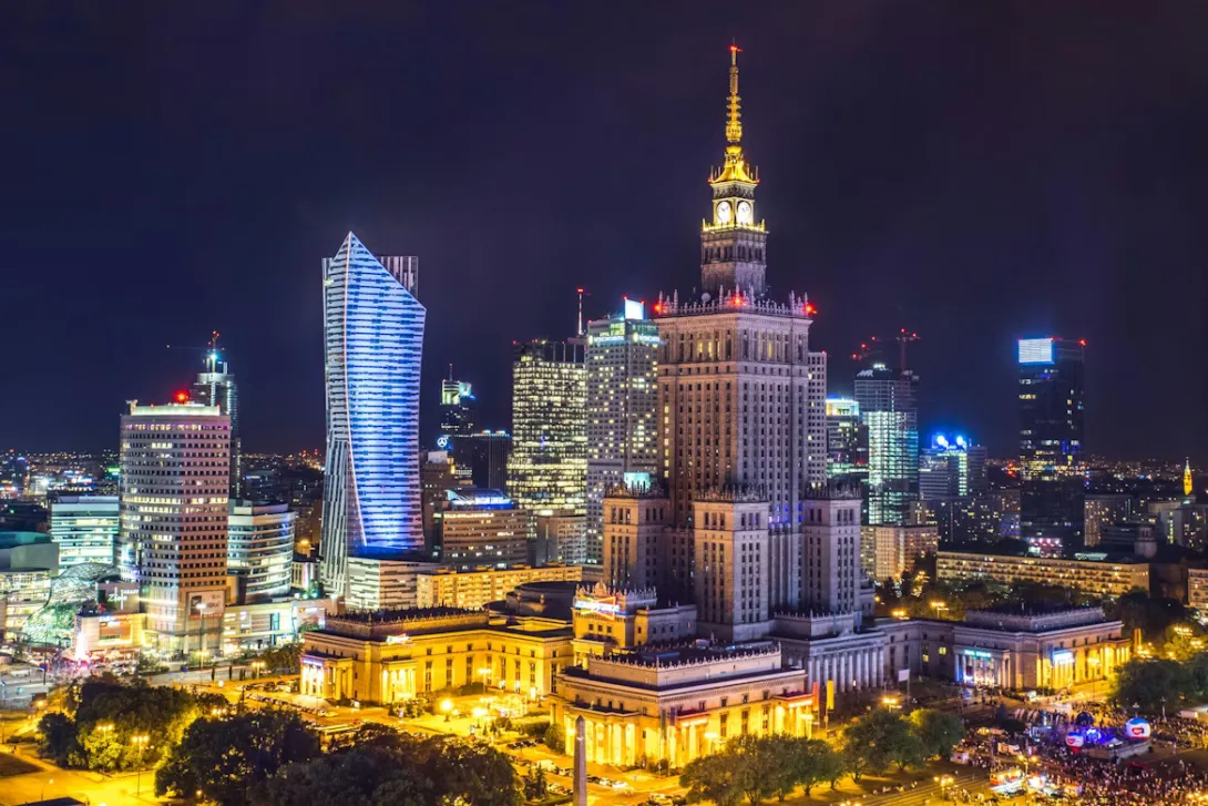Panoramic view of Warsaw city center with historic Old Town architecture, modern skyscrapers, the Vistula River, and urban skyline in Poland during golden hour.