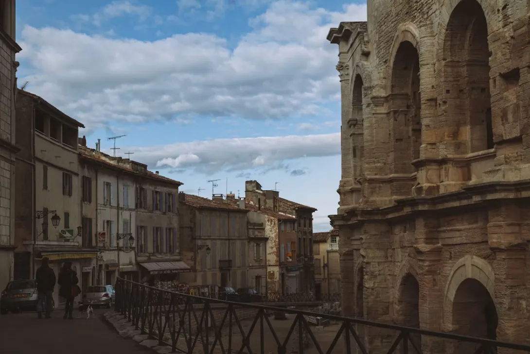 Panoramic view of Arles, France, featuring the historic Rhône River, Roman architecture, terracotta rooftops, and the charming Provençal cityscape under a bright Mediterranean sky.