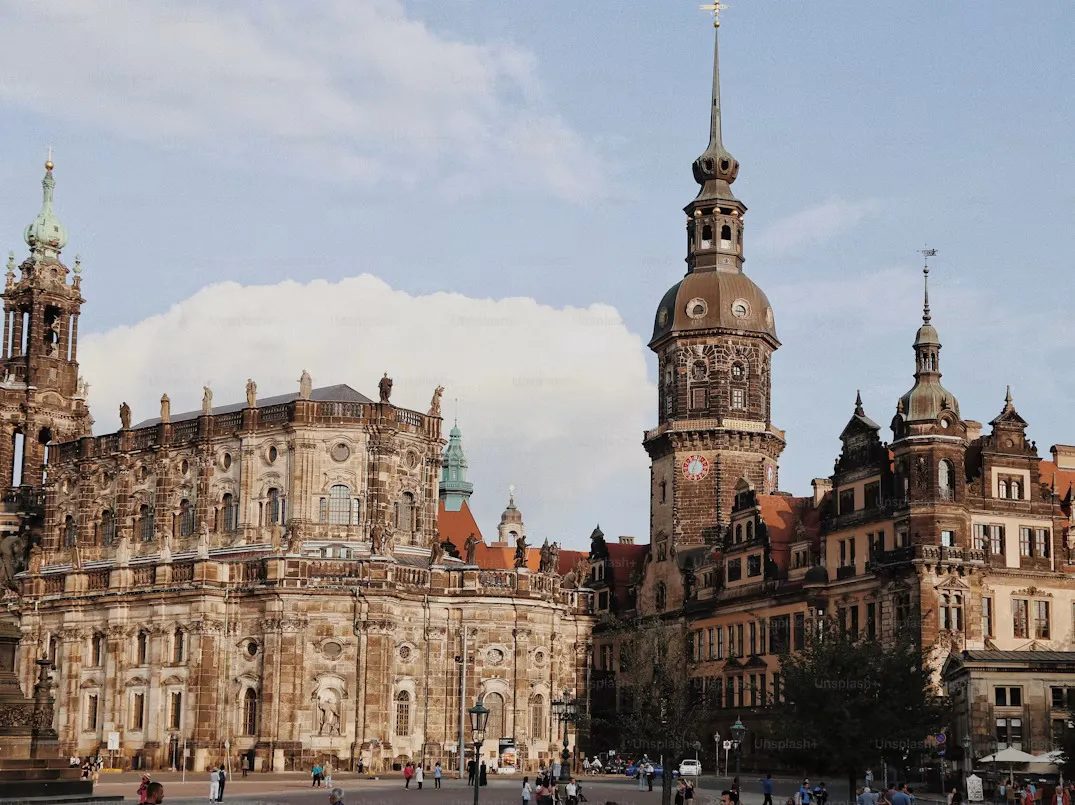 Panoramic view of Dresden, Germany, featuring the Elbe River, historic baroque skyline, domes and bridges, and surrounding green hills under a soft morning sky.